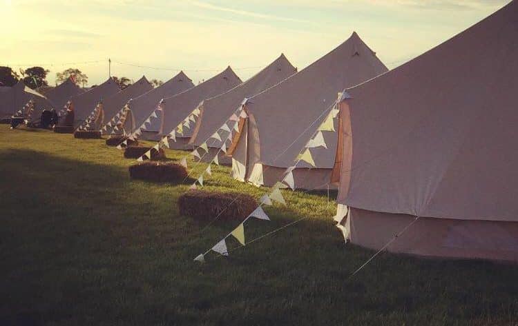 A row of bell tents stretching into the distance